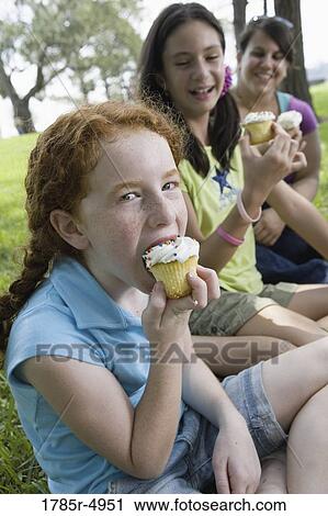 Children and their teacher eatingcupcakes at a park View Large Photo Image Stock Image - Children and their teacher eatingcupcakes at a park. Fotosearch