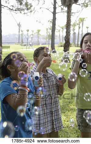 Children blowing bubbles at a park View Large Photo Image Picture - Children blowing bubbles at a park. Fotosearch