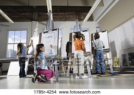 Children drawing on easels in art class View Large Photo Image Picture - Children drawing on easels in art class. Fotosearch