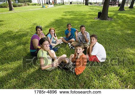 Children sitting in a circle on the grass with their teacher at a park View Large Photo Image Stock Photograph - Children sitting in a circle on the grass with their teacher at a park. Fotosearch