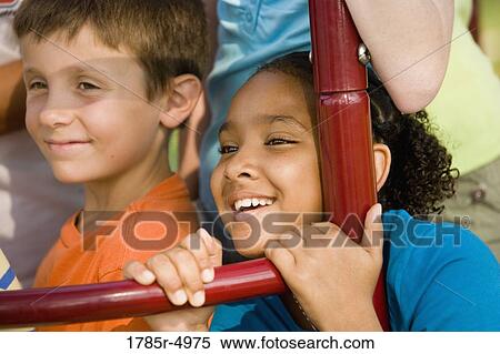 Close-up of a boy and girl climbing on monkey bars at a playground View Large Photo Image Stock Photography - Close-up of a boy and girl climbing on monkey bars at a playground. Fotosearch