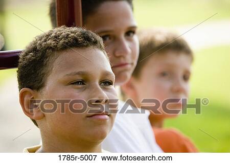 Close-up of a boy with friends in the background View Large Photo Image Stock Photo - Close-up of a boy with friends in the background. Fotosearch