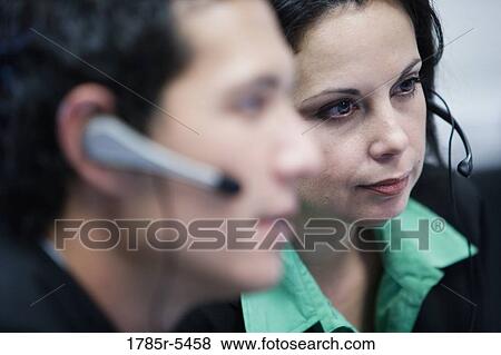 Stock Photo - Close-up of a business woman with colleague in foreground. Fotosearch