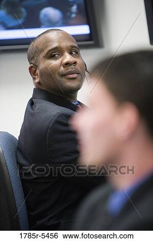 Close-up of a businessman looking over his shoulder View Large Photo Image Stock Photograph - Close-up of a businessman looking over his shoulder. Fotosearch
