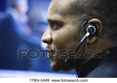 Close-up of a businessman with headset View Large Photo Image Stock Photo - Close-up of a businessman with headset. Fotosearch