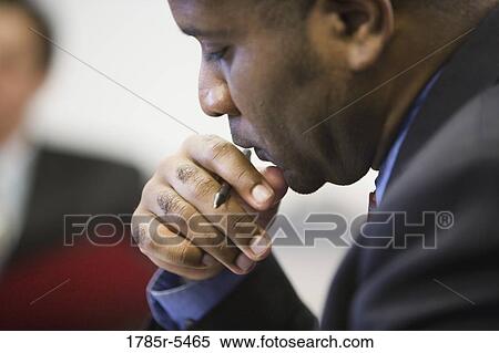 Close-up of a contemplative businessman with pen in hand View Large Photo Image Stock Photography - Close-up of a contemplative businessman with pen in hand. Fotosearch