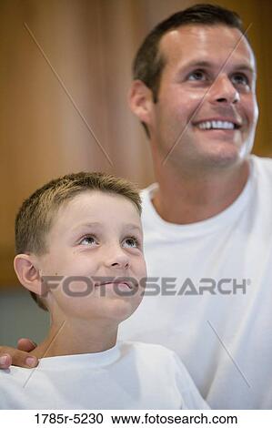 Close-up of a father and a son looking up View Large Photo Image Stock Image - Close-up of a father and a son looking up. Fotosearch