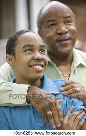 Close-up of a father embracing his son View Large Photo Image Stock Photography - Close-up of a father embracing his son. Fotosearch