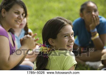 Close-up of a girl at a park with her friends and teacher in the background View Large Photo Image Stock Photograph - Close-up of a girl at a park with her friends and teacher in the background. Fotosearch