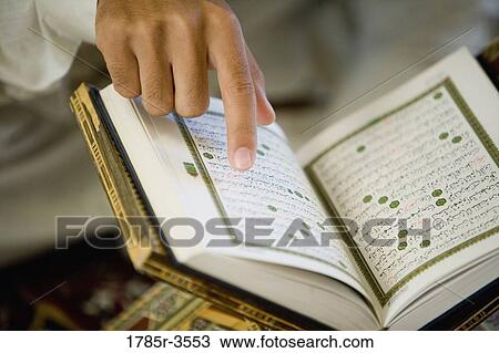 Close-up of a hand pointing at Koran View Large Photo Image Stock Image - Close-up of a hand pointing at Koran. Fotosearch