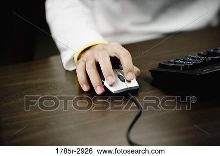 Stock Photograph - Close-up of a human hand using computer mouse. Fotosearch