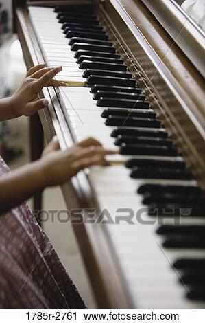 Close-up of a little girl's hands playing piano View Large Photo Image Stock Image - Close-up of a little girl's hands playing piano. Fotosearch