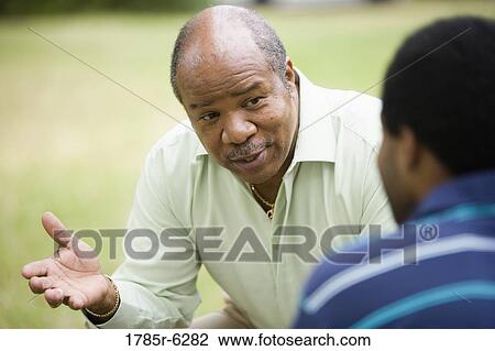 Close-up of a mature man talking to adult son View Large Photo Image Stock Image - Close-up of a mature man talking to adult son. Fotosearch