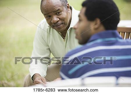 Close-up of a mature man talking to adult son View Large Photo Image Stock Image - Close-up of a mature man talking to adult son. Fotosearch