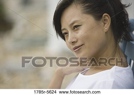 Picture - Close-up of a pretty young Asian woman smiling. Fotosearch