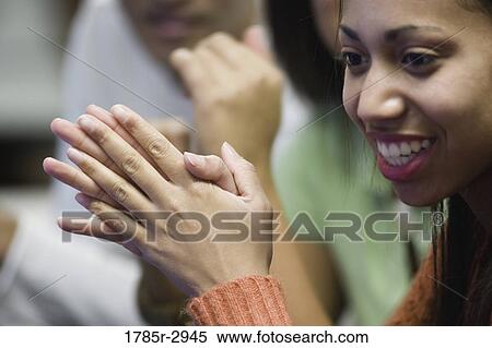 Close-up of a smiling young woman with hands clasped View Large Photo Image Stock Photography - Close-up of a smiling young woman with hands clasped. Fotosearch