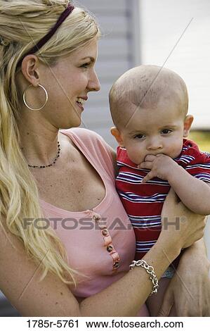 Close-up of a woman holding with her baby View Large Photo Image Stock Image - Close-up of a woman holding with her baby. Fotosearch