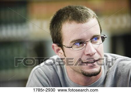 Stock Image - Close-up of a young man wearing glasses. Fotosearch