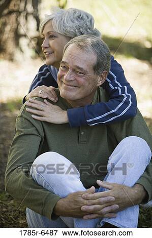 Stock Photo - Close-up of affectionate mature couple sitting outdoors. Fotosearch