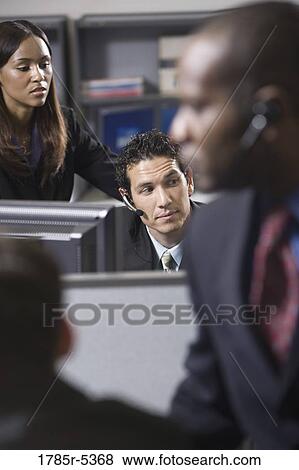Stock Photo - Close up of business people working in a busy office. Fotosearch