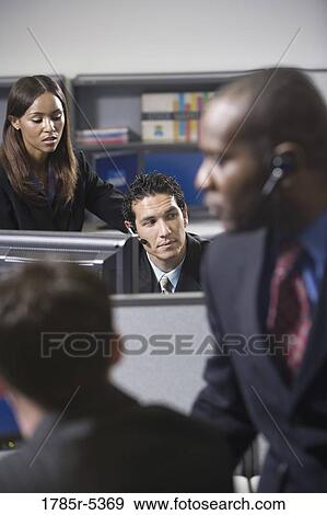 Stock Photo - Close up of business people working in a busy office. Fotosearch