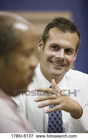 Stock Photo - Close up of businessmen conversing. Fotosearch