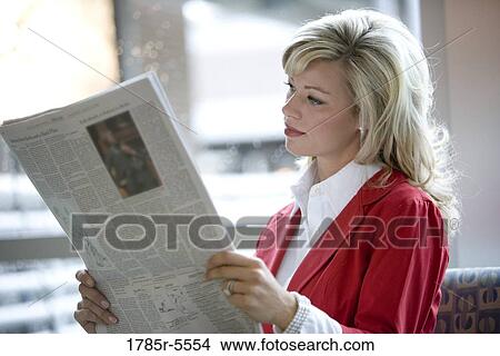 Picture - Close-up of businesswoman reading newspaper. Fotosearch