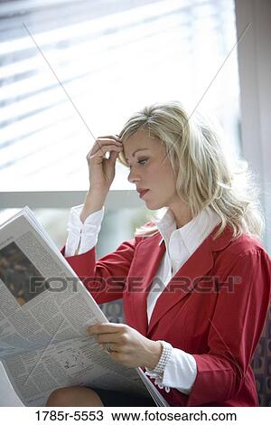 Stock Image - Close-up of businesswoman reading newspaper. Fotosearch