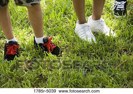 Stock Photo - Close-up of children's shoes standing on grass. Fotosearch