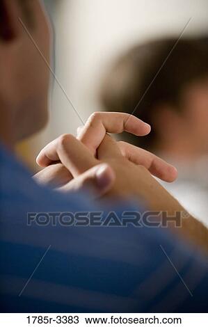 Stock Image - Close-up of clasped hands. Fotosearch
