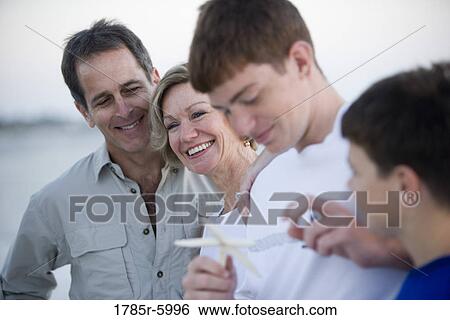 Close-up of family at the beach looking at starfish View Large Photo Image Stock Photograph - Close-up of family at the beach looking at starfish. Fotosearch