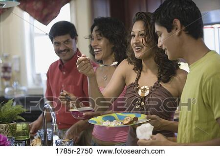 Close up of family in kitchen eating food View Large Photo Image Stock Image - Close up of family in kitchen eating food. Fotosearch
