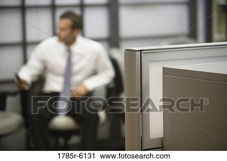 Stock Image - Close-up of file cabinet out-of-focus man in background. Fotosearch