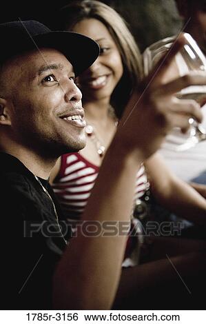Close-up of group of young friends socializing View Large Photo Image Stock Photograph - Close-up of group of young friends socializing. Fotosearch