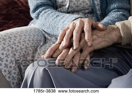Stock Photo - Close up of holding hands of senior couple. Fotosearch