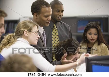 Close-up of office workers gathered around computer View Large Photo Image Picture - Close-up of office workers gathered around computer. Fotosearch