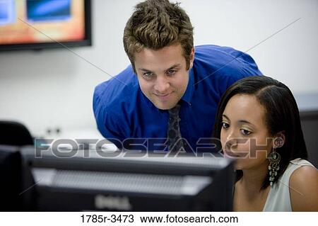 Close-up of office workers gathered around computer View Large Photo Image Stock Image - Close-up of office workers gathered around computer. Fotosearch