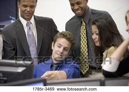 Close-up of office workers gathered around computer View Large Photo Image Stock Photo - Close-up of office workers gathered around computer. Fotosearch