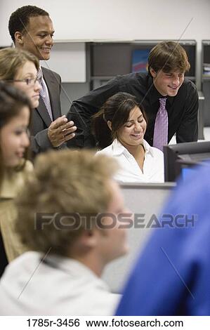 Close-up of office workers gathered around computer View Large Photo Image Stock Photograph - Close-up of office workers gathered around computer. Fotosearch