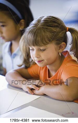 Stock Image - Close up of two little girls in class. Fotosearch