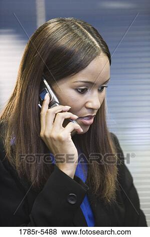 Stock Photo - Close up of young African woman using mobile phone. Fotosearch