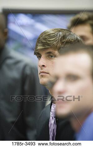 Stock Image - Close-up of young businessmen watching. Fotosearch
