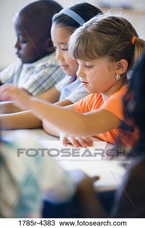 Stock Image - Close up of young children in class. Fotosearch