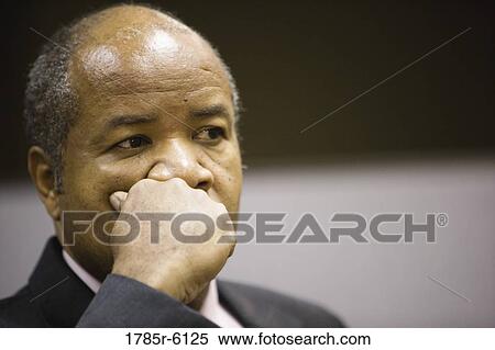 Close-up view of contemplative businessman with hand on chin View Large Photo Image Stock Photography - Close-up view of contemplative businessman with hand on chin. Fotosearch