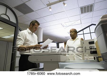 Co-workers using office equipment View Large Photo Image Stock Image - Co-workers using office equipment. Fotosearch