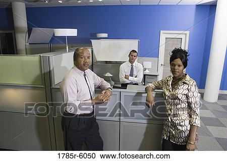 Colleagues meeting at an office cubicle View Large Photo Image Stock Image - Colleagues meeting at an office cubicle. Fotosearch