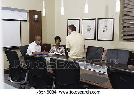 Colleagues working together in a conference room View Large Photo Image Picture - Colleagues working together in a conference room. Fotosearch