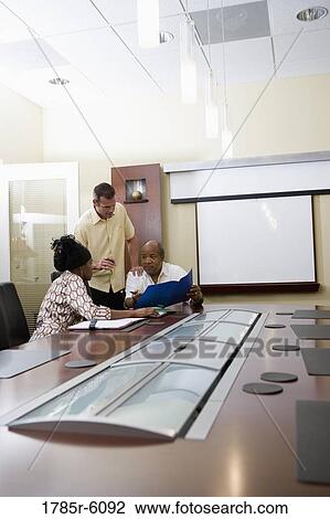 Colleagues working together in a conference room View Large Photo Image Stock Image - Colleagues working together in a conference room. Fotosearch