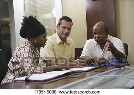 Colleagues working together in a conference room View Large Photo Image Stock Photo - Colleagues working together in a conference room. Fotosearch