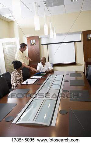 Stock Photography - Colleagues working together in a conference room. Fotosearch